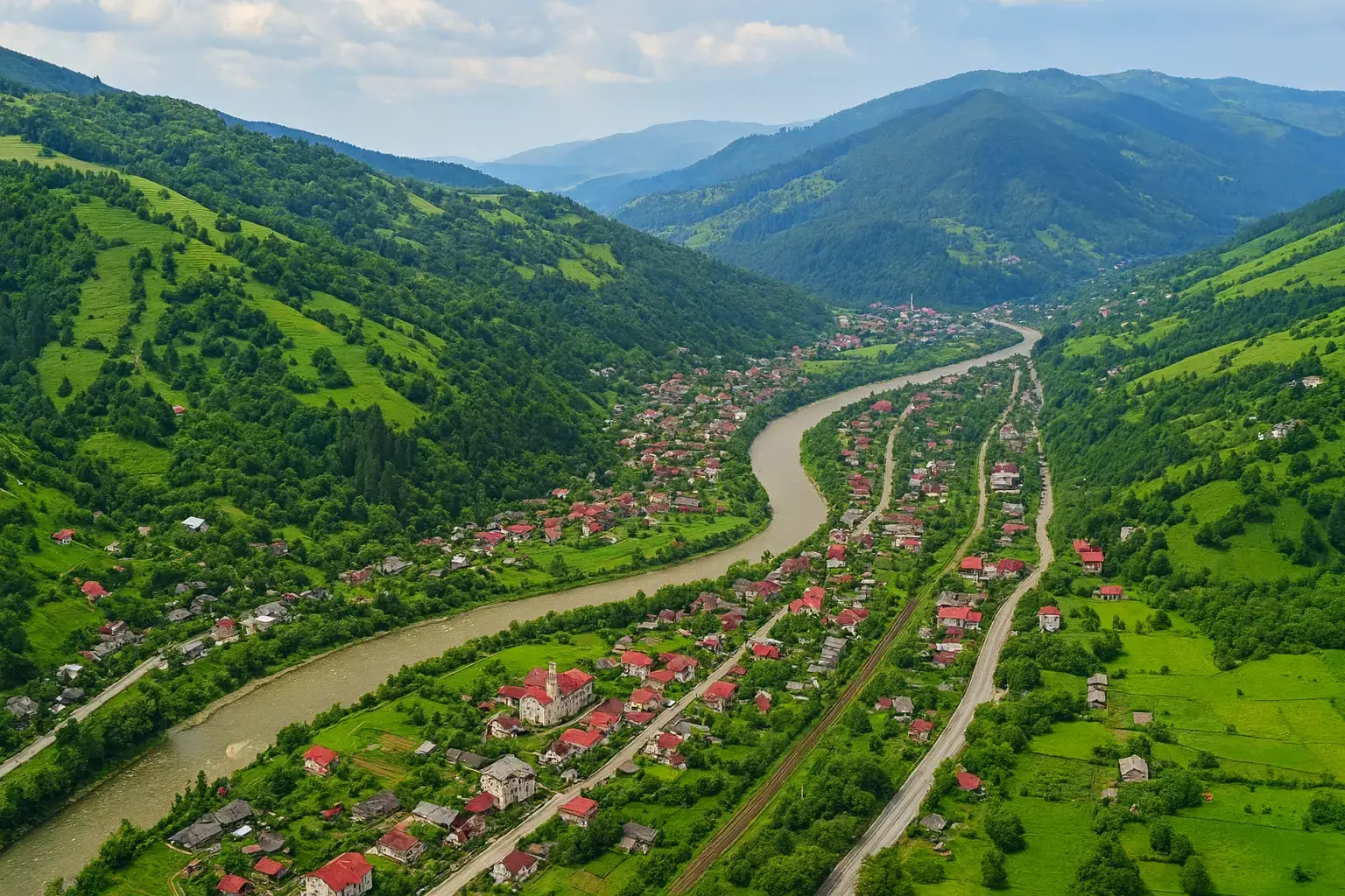 Orașul Rakhiv, situat într-o vale între versanți montani, de-a lungul unui râu șerpuitor și a unei linii de cale ferată 