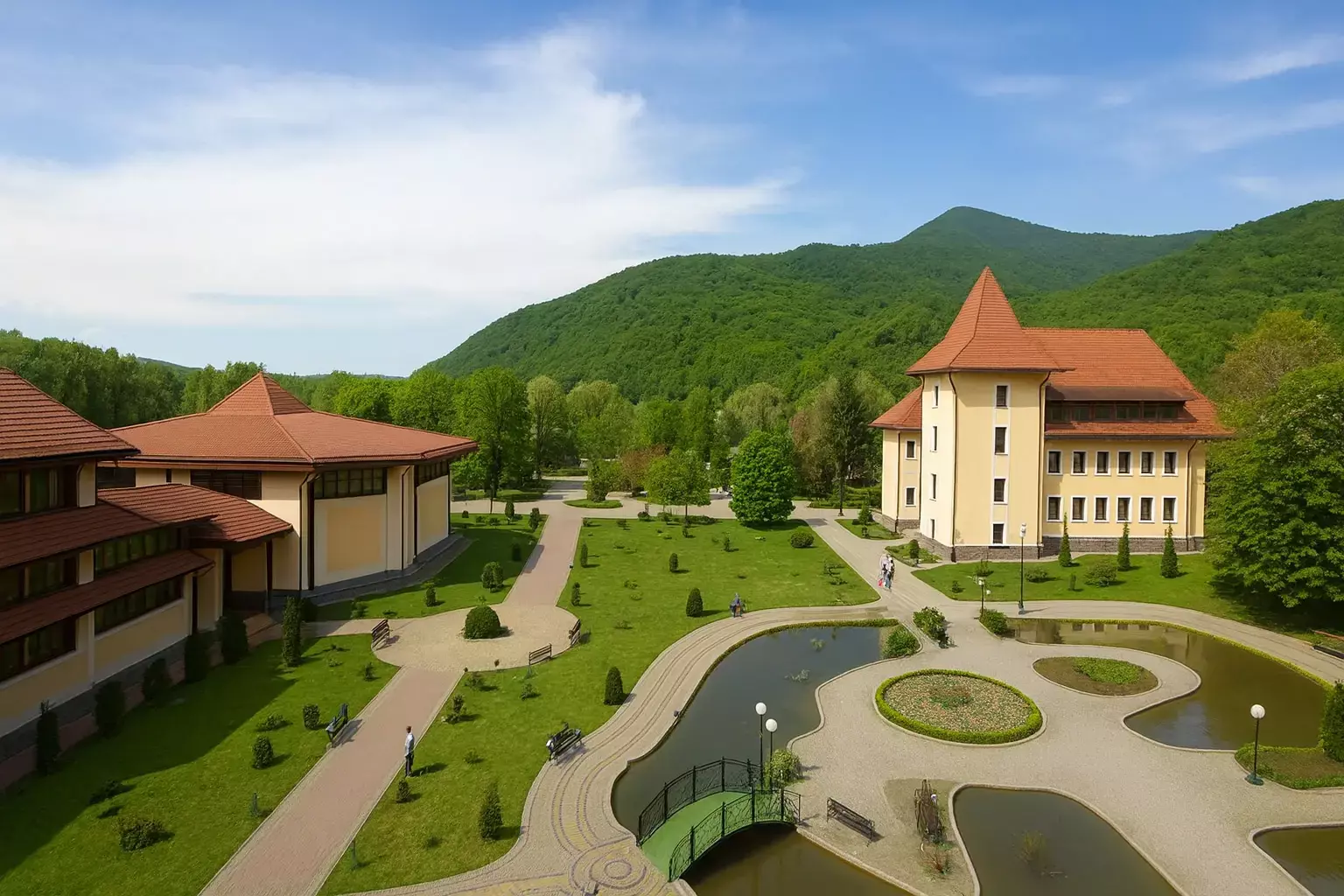 Stațiunea Svalyava cu un parc îngrijit, iazuri și clădiri hoteliere pe fundalul munților verzi            